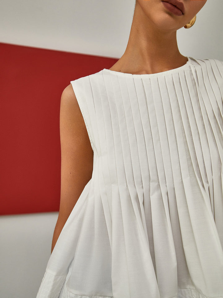 Blouse sans manches à basque plissée