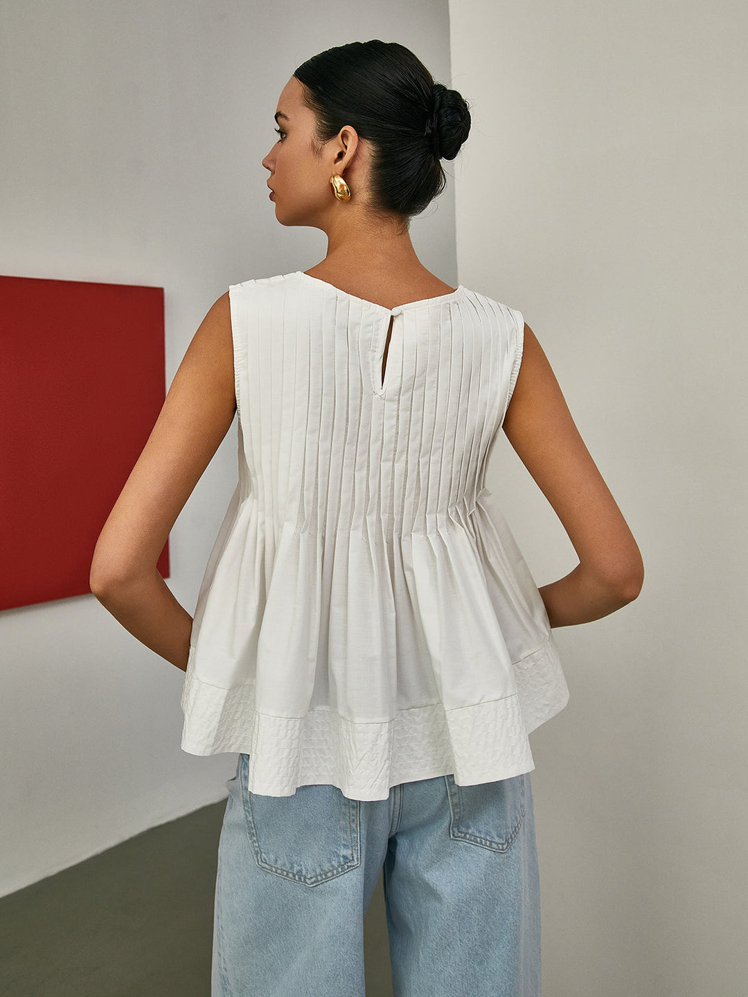 Blouse sans manches à basque plissée
