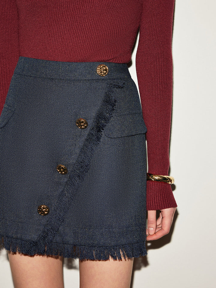 Mini-jupe boutonnée mi-taille en tweed avec pompon