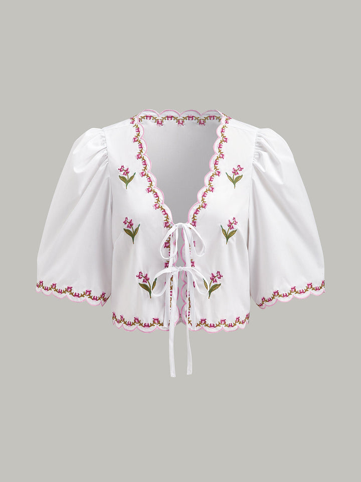 Blouse à manches bouffantes avec bordure festonnée et nœud brodé