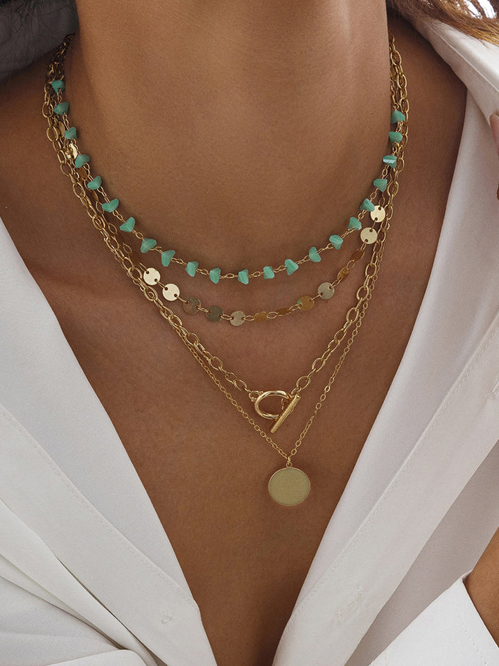 Collier à chaîne en or superposé avec perles de turquoise et pendentif circulaire