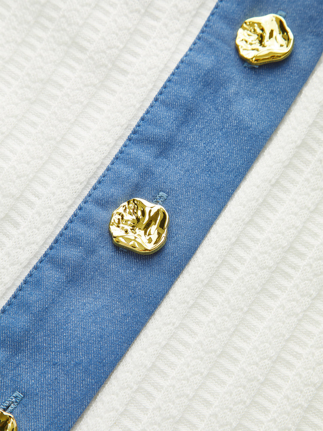 Mini-jupe en tricot avec bordure en jean et bouton en métal