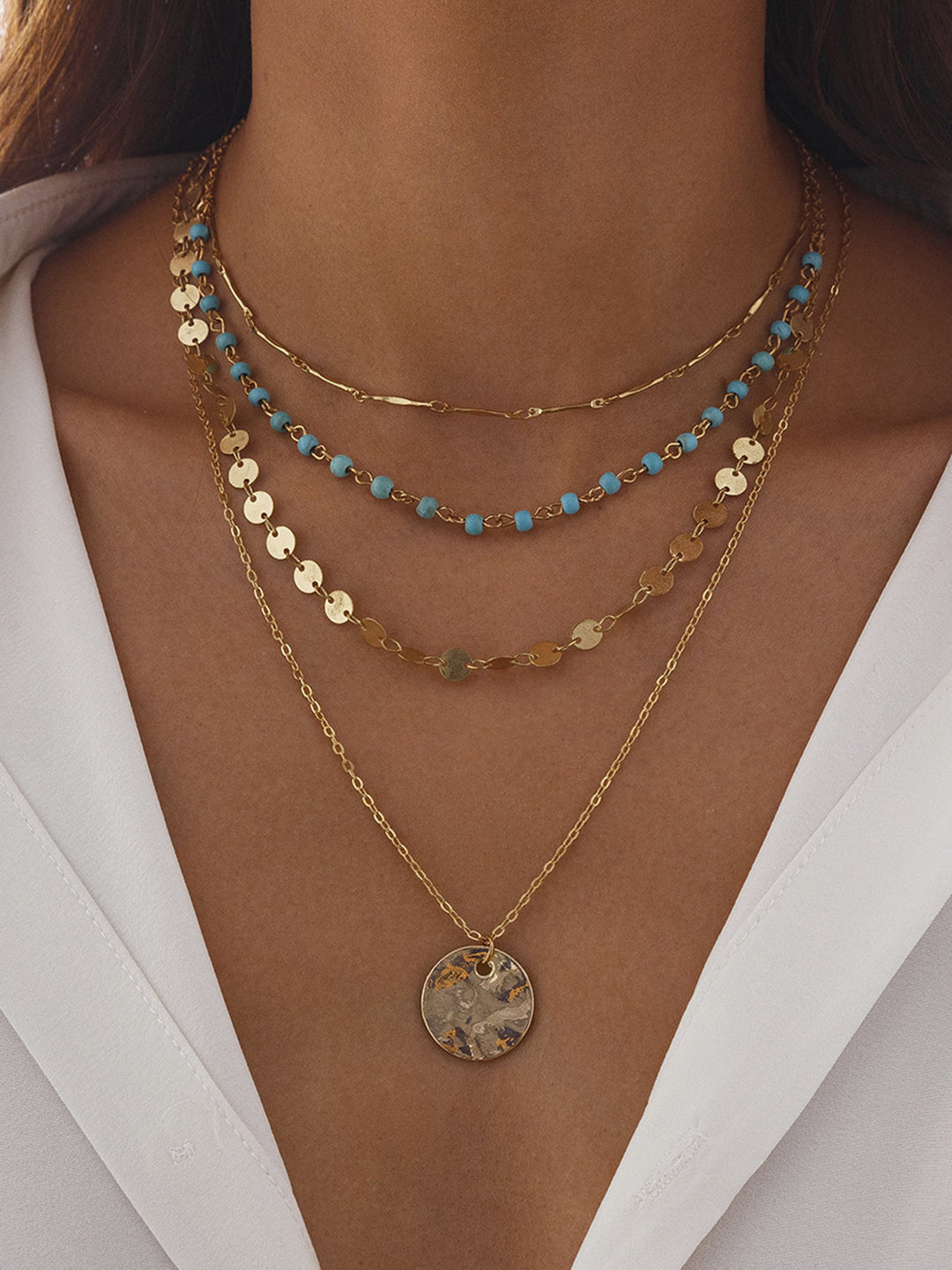 Collier à plusieurs rangs à finition dorée avec perles et pendentif disque