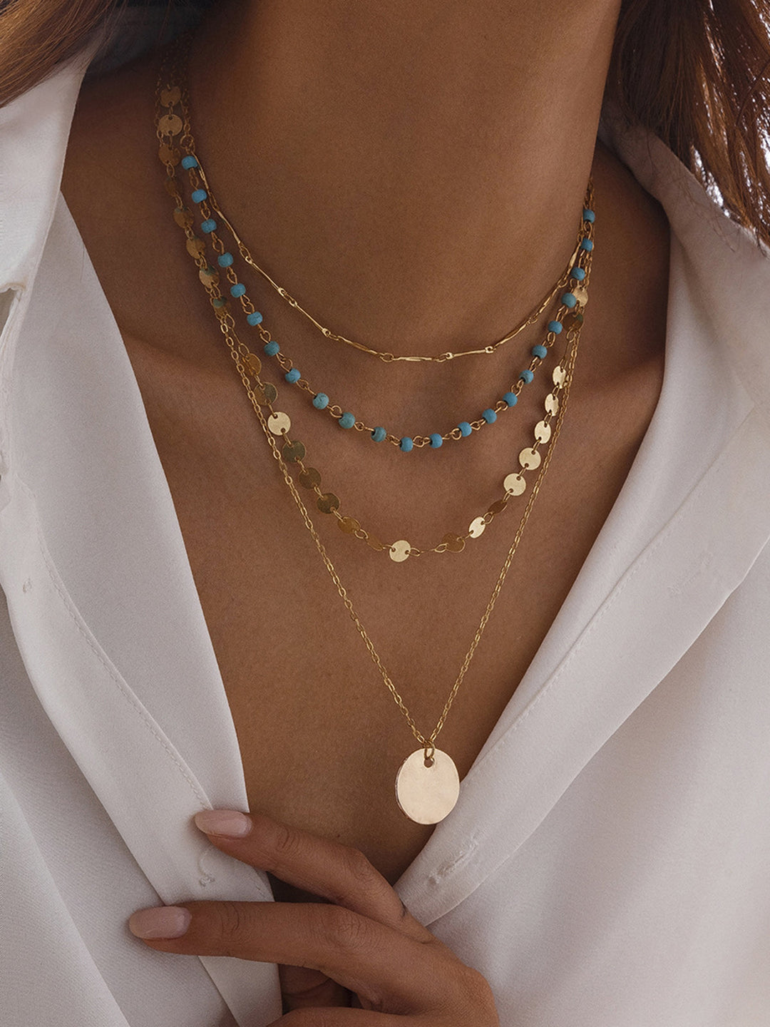 Collier à plusieurs rangs à finition dorée avec perles et pendentif disque